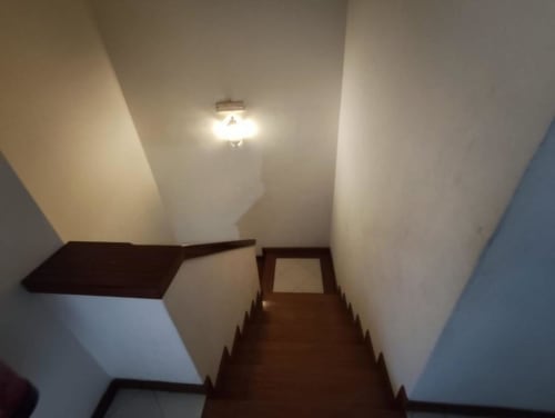 Escada com degraus de madeira e paredes brancas ascendentes no apartamento Albufeira Inn, com luminária no teto