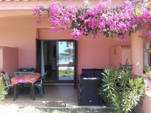 Pátio vibrante em rosa da Albufeira Inn com buganvílias, mobiliário preto e terraço com vista para o jardim