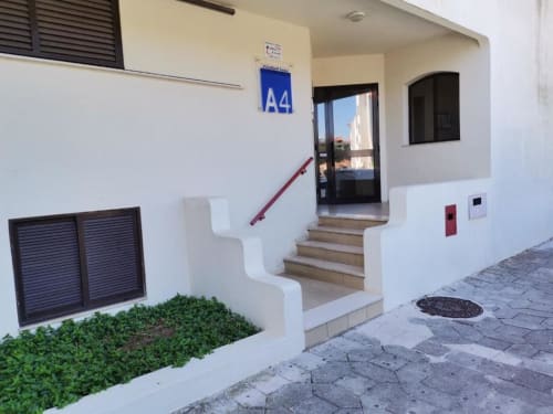 Entrada do apartamento A4 do Bellavista Tenis Clube na Albufeira Inn, com escadas de corrimão vermelho e vista para jardim