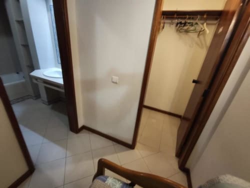Corredor do apartamento Albufeira Inn com marcos de madeira, piso em azulejo e acesso à cozinha e quartos