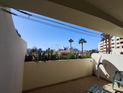 Terraço ensolarado da Albufeira Inn com palmeiras, vistas da cidade e edifícios de apartamentos em Albufeira, Portugal