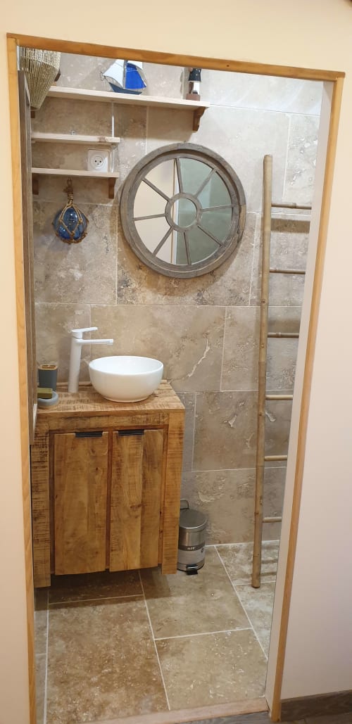 Salle de bains nautique à l'hôtel Vesta Gaia à Saint-Gilles avec vasque navire, miroir hublot et décor côtier