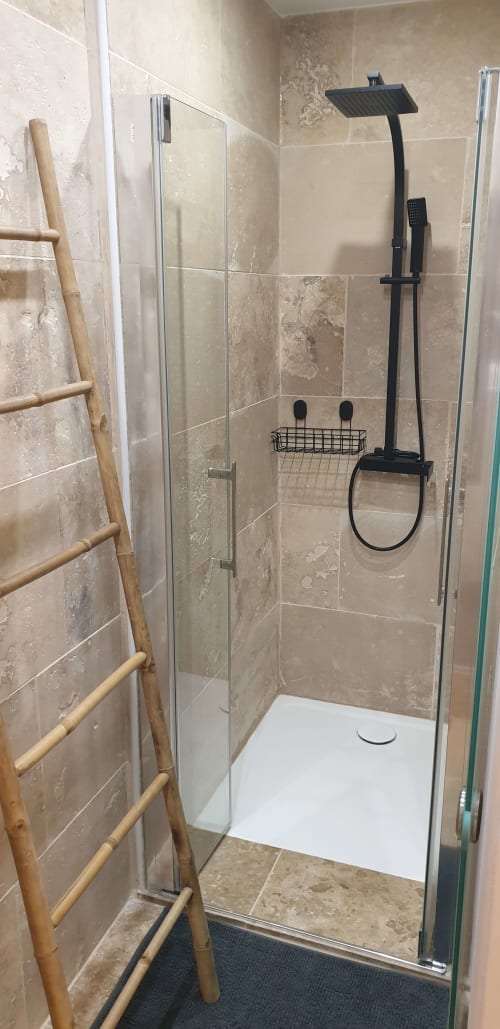 Douche moderne à l'hôtel Vesta Gaia à Saint-Gilles avec pommeau de douche pluie et accessoires noirs