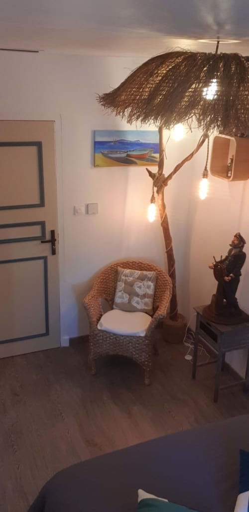 Coin lecture douillet à Vesta Gaia avec fauteuil en osier, lampe tressée et art marin