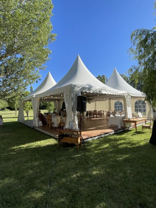 Élégante tente blanche pour événement aux Jardins Du Soleil à Avignon avec tables en bois et ciel dégagé