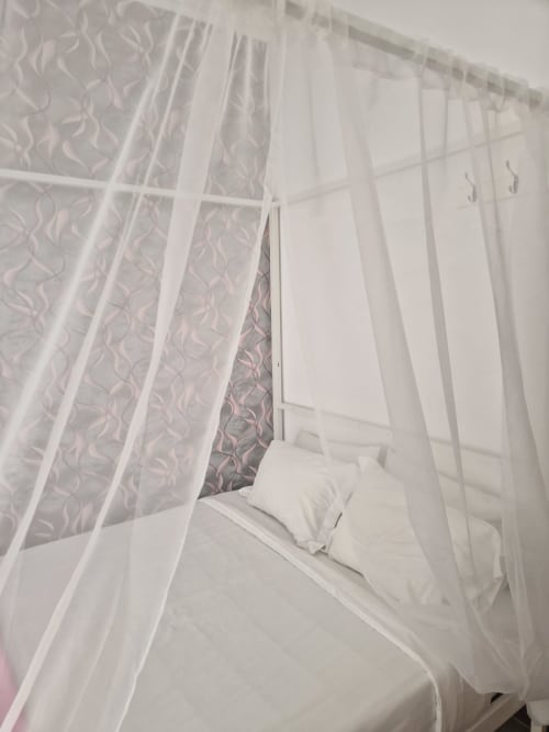 Canopy bed with sheer white curtains at Zuni Guest House, Lisboa, double room with shared bathroom