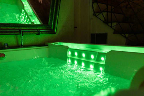 Vasca idromassaggio illuminata con luci LED verdi nella spa Caveau di Oltre Exclusive a Palermo