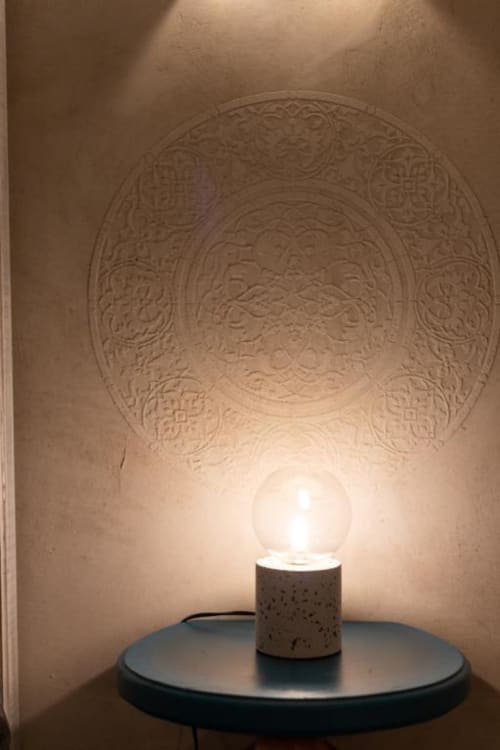 Atmosfera minimalista in spa con lampada illuminata su tavolo scuro che diffonde luce sul soffitto decorato nell'esclusivo appartamento di Palermo