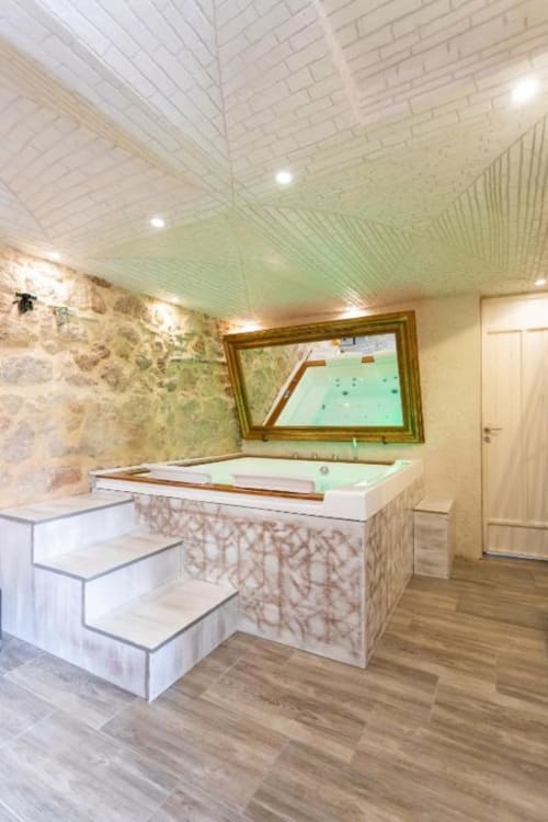 Lussuoso bagno spa all'Oltre Exclusive & Caveau di Palermo con vasca idromassaggio incassata, dettagli in marmo e comfort moderni.