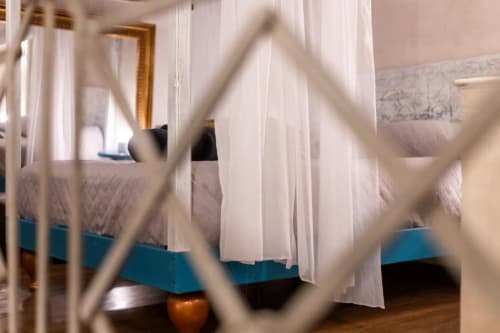 Camera da letto lussuosa con tende bianche trasparenti, pavimenti in legno e parete azzurra all'hotel Oltre Exclusive di Palermo
