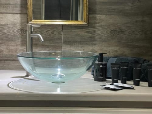 Bagno spa moderno con lavabo in vetro, specchio dorato e lussuosi articoli da toilette presso Oltre Exclusive a Palermo