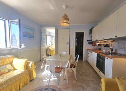 Luminosa cucina a pianta aperta e zona living con dettagli gialli presso Pura Vita Apartments, Monopoli