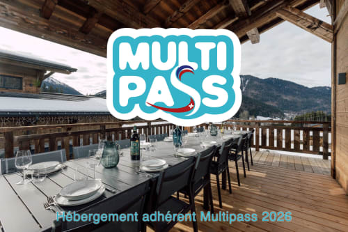 Terrasse montagne Altitudia Morzine aménagée pour les repas avec le logo Multipass 2026, massifs alpins en arrière-plan