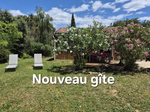 Jardin du gîte Domaine en Terre Happy avec chaises longues, arbustes fleuris et villa de style toscan à Labastide-de-Virac