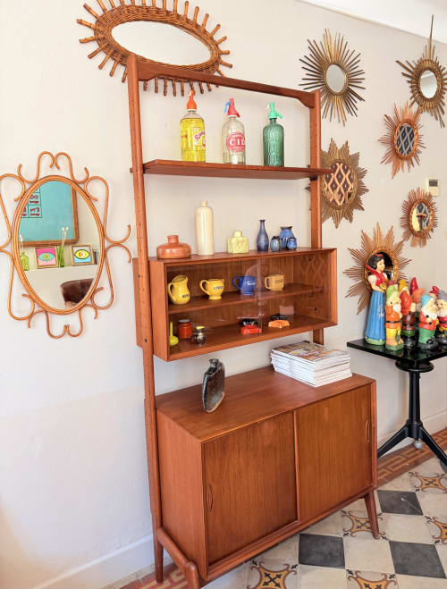 Vintage mid-century wooden cabinet display with colorful collectibles at Hôtel La Suite in Villeneuve-lès-Avignon