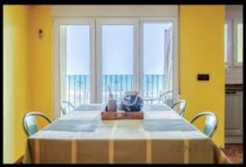 Bright yellow dining room with sea view balcony at Pataconablue Rentals, Valencia apartment
