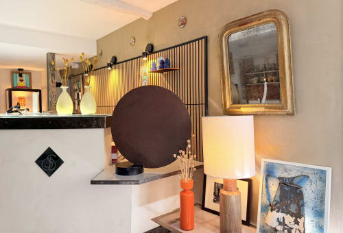 Hôtel La Suite reception desk in Villeneuve-lès-Avignon features modern décor with large brown sphere sculpture and