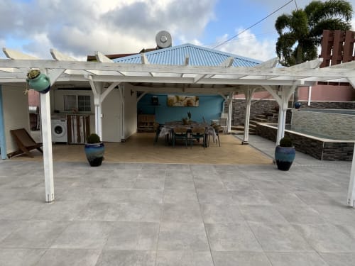 Terrasse extérieure de la Résidence B&L Lagon avec pergola , coin repas et terrasse aux accents turquoise à Sainte-Luce, Martinique