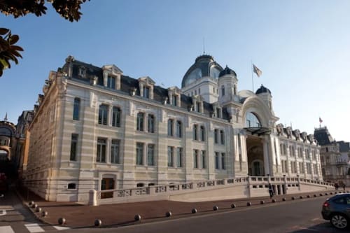 Hôtel Les Triolets, an elegant Belle Époque building in Châtel, France with cream façade and mansard roof.