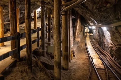 Underground salt mine tunnel with wooden support beams and railway tracks, Châtel France