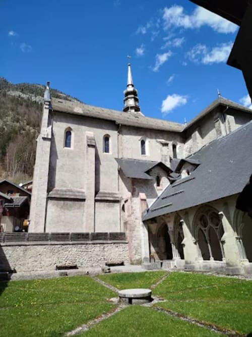 Historic stone church with spire in Châtel, France, near Hôtel Les Triolets