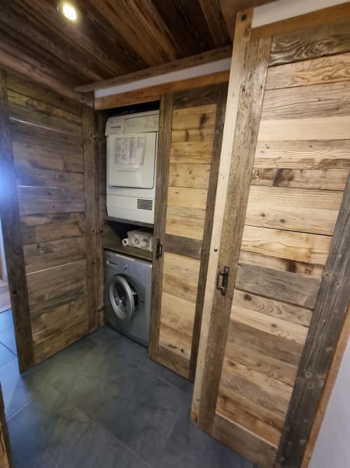 Buanderie rustique avec machine à laver et sèche-linge dans un appartement à Courchevel