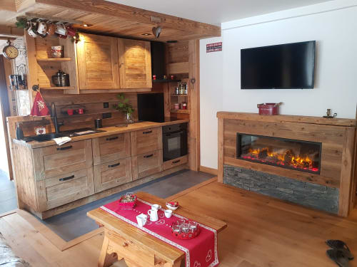 Appartement cosy à Courchevel avec cuisine en bois, cheminée, télévision et salle à manger au style chalet montagnard