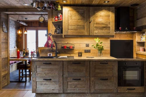 Cuisine rustique en bois dans appartement à Courchevel avec plaque induction, four noir et accès vue montagne