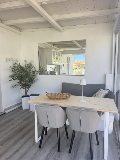 Moderna zona pranzo nell'Apartment CoralBay di Villa Carrie Porto Pozzo, con tavolo in legno, sedie rivestite in grigio e