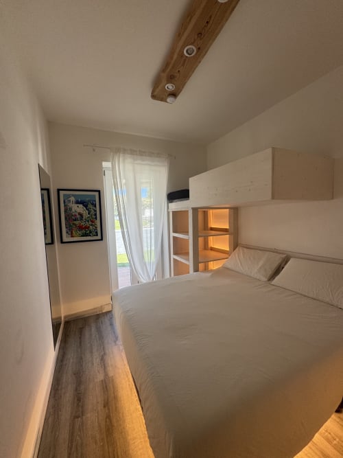 Camera luminosa in CoralBay Apartment a Villa Carrie Porto Pozzo, Gallura, con letto matrimoniale, soppalco, porte in vetro