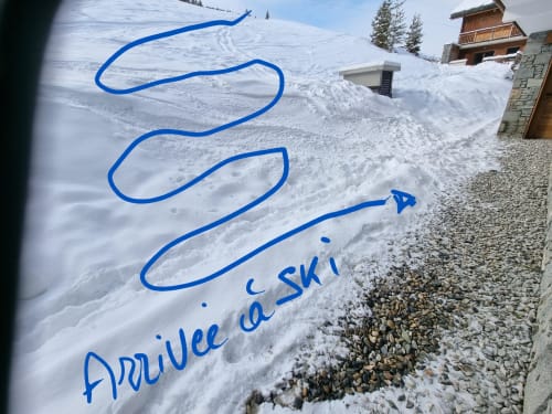 Pistes de ski à Courchevel avec annotations bleues indiquant les domaines skiables au-dessus du hotel Zoppas, vue du village montagnard