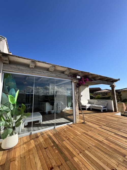 Terrazza panoramica dell'Apartment Starfish presso Villa Carrie Porto Pozzo con solarium in legno, arredamento lounge e vista mare a Santa