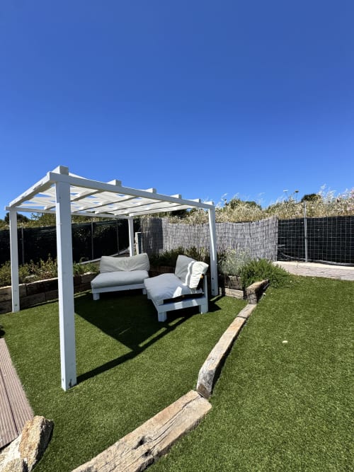 Moderno pergolato bianco con lettini sdraiati su prato verde a Villa Carrie Porto Pozzo, Santa Teresa Gallura