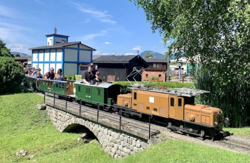 Miniature train ride at Hôtel Les Triolets in Châtel with visitors on bridge over tracks