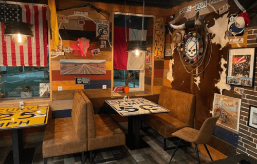 Vintage Route 66 themed dining booth with wood seating and retro Americana décor at Clos Céleste guesthouse, Ecrainville