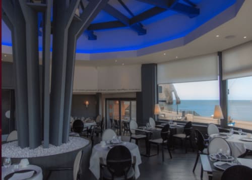 Elegant dining room at Clos Céleste with blue curved ceiling, ocean views, and coastal French setting in Étretat