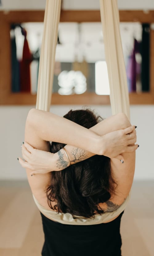Femme en posture de yoga, bras croisés, à la boutique hôtel Maison la Chèvre à Essaouira, Maroc