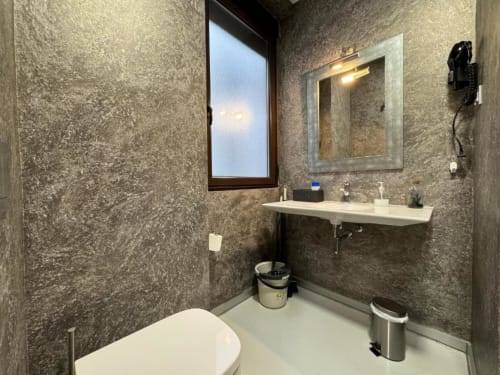 Baño moderno en Apartamentos RJ26 León con paredes de azulejos, lavabo, espejo y ventana