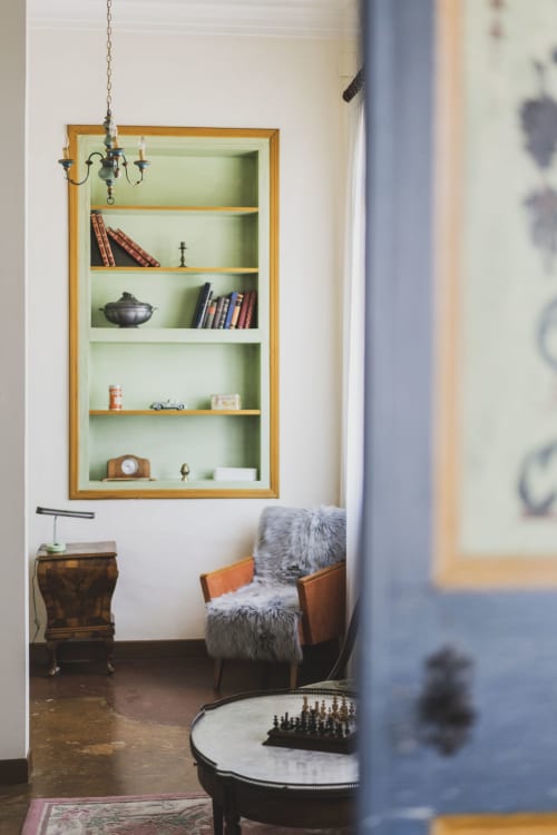 Elegant reading nook at Villa Stecchini Resort with wooden shelving, leather chair, and vintage decor in Romano d'Ezzelino