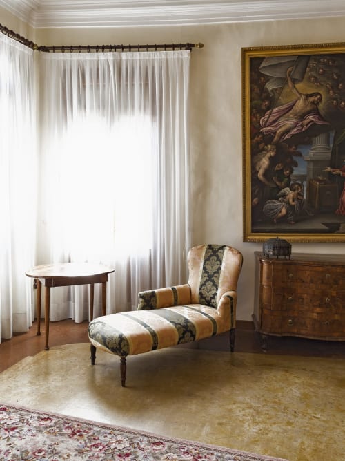 Suite elegante a Villa Stecchini Resort con sdraio rigata, arredamento in legno e opere d'arte classica nello stile Romano