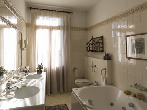Elegante suite bagno a Villa Stecchini Resort con doppio lavabo, vasca idromassaggio e luce naturale dalle finestre