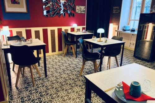 Salle à manger moderne à l'Au Richebourg Nogent B&B avec murs rayés rouge et crème, carrelage à motifs, chaises noires