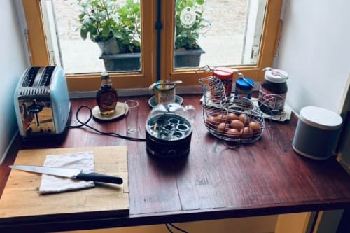 Plan de travail de la cuisine de la chambre d'hôtes Au Richebourg Nogent avec grille-pain, œufs, plantes et essentiels de cuisine