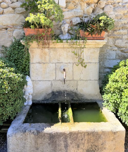 Stone water fountain with decorative plantings at Hôtel La Suite in Villeneuve-lès-Avignon, France