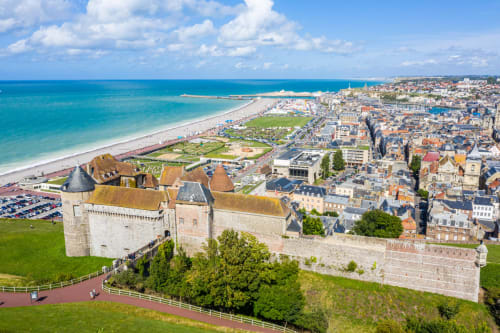Aerial view of Mers-les-Bains beach and historic castle overlooking coastal town in Normandy, France