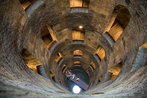 Antico pozzo in pietra a spirale con travi in legno e acqua in fondo, Orvieto, Italia bed and breakfast