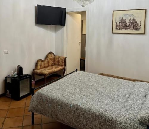 Deluxe Double Room presso Domus Giovanna Roma, con letto, divano vintage, TV a schermo piatto e vista sulla corte interna