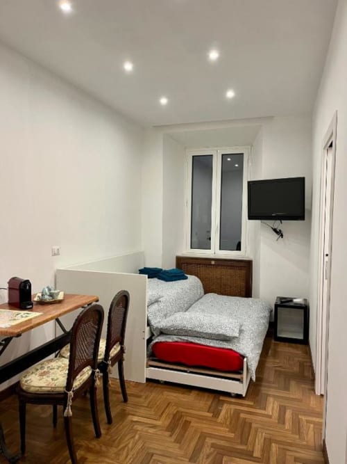 Camera moderna con zona lavoro, TV e letti gemelli su pavimento a spina di pesce presso Domus Giovanna B&B Roma