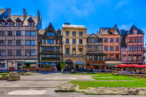 Historic half-timbered buildings in Rouen's Old Town square, Normandy France with colorful facades and outdoor café seating
