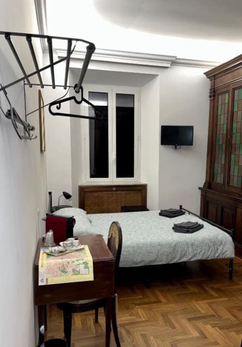 Accogliente camera da letto presso il Domus Giovanna B&B a Roma con letto matrimoniale, mobili in legno e TV